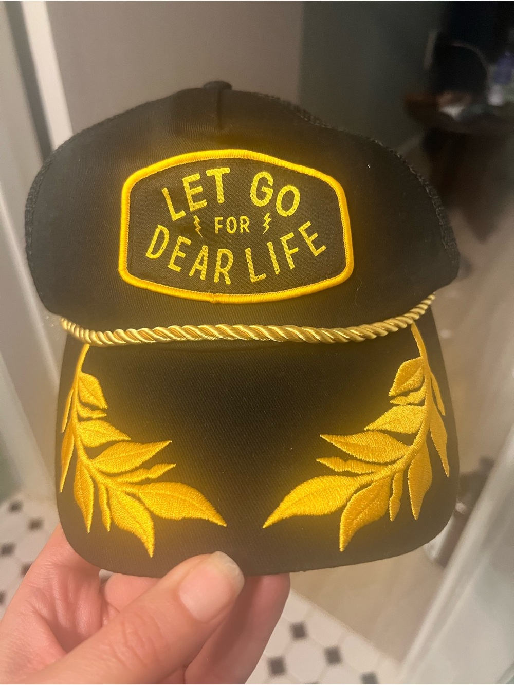 Black Trucker Cap with Yellow Embroidered 'LET GO FOR DEAR LIFE' Patch